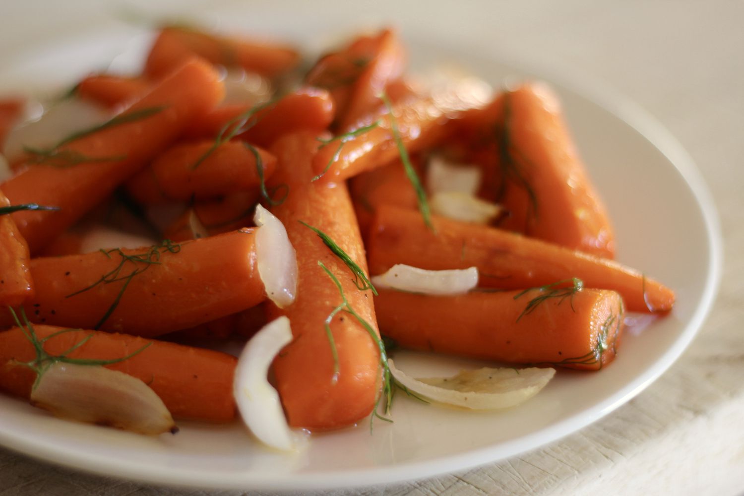 Жареная морковь и лук с листьями фенхеля и меда